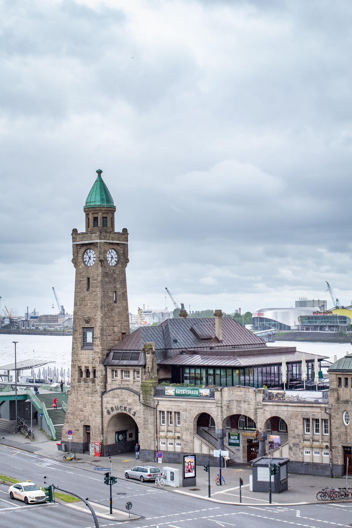 Blick auf die St. Pauli Landungsbrücken in Hamburg mit Pegelturm, dahinter Elbe und Hafen